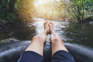 Man floating down a canal in a blow up tube